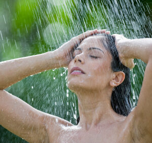 Young woman under an outside shower